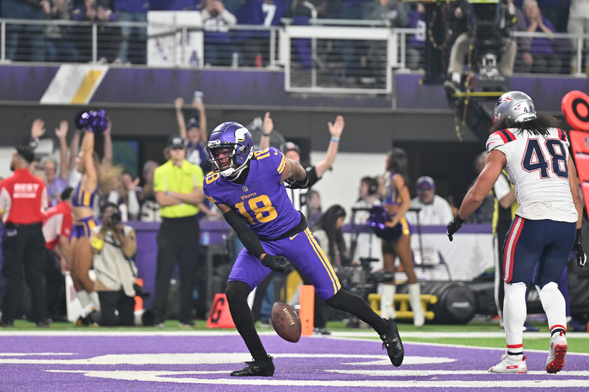 Nov 24, 2022; Minneapolis, Minnesota, USA; Minnesota Vikings wide receiver Justin Jefferson (18) reacts after a touchdown as New England Patriots linebacker Jahlani Tavai (48) looks on during the first quarter at U.S. Bank Stadium. 